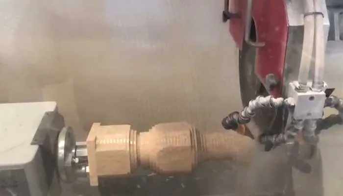 عمود CNC بأدوات برونزية يشكّل الحجر وسط رشاش الماء