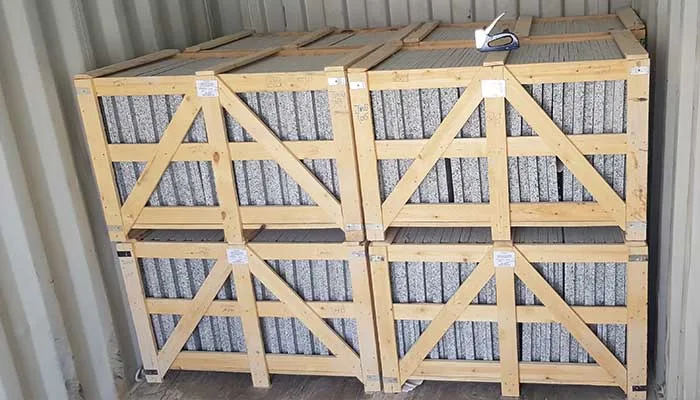 بلاطات جرانيت رمادية في صناديق ومحمّلة داخل حاوية شحن
