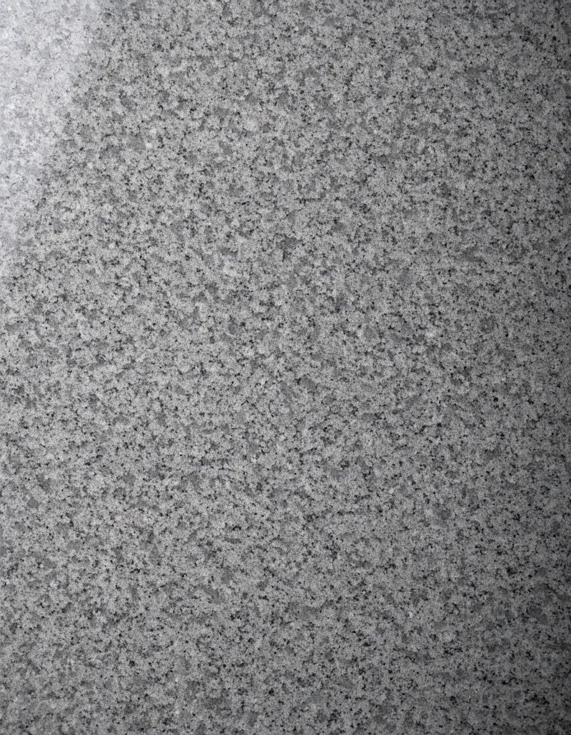 A polished slab of Karnak Grey granite, an even mid-grey with a fine, regular speckle